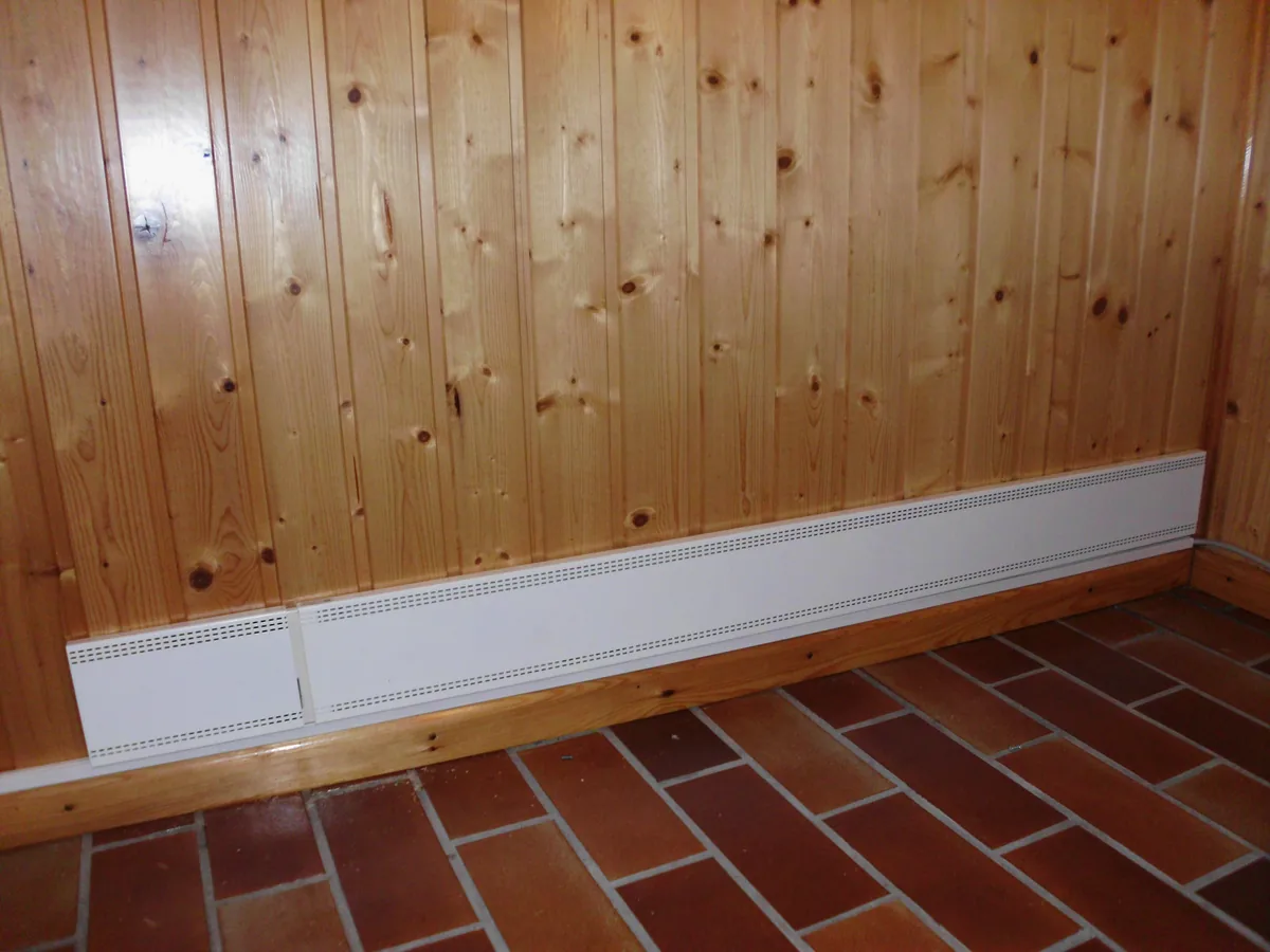 Lange Fußleistenheizung entlang einer Holzverkleidung