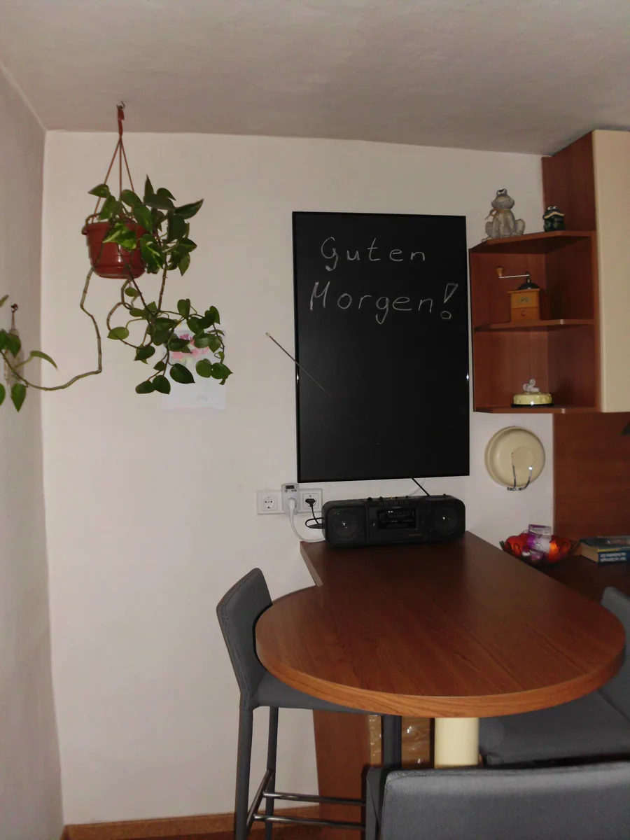 Schwarze Infrarotheizung in Tafeloptik über einem Esstisch